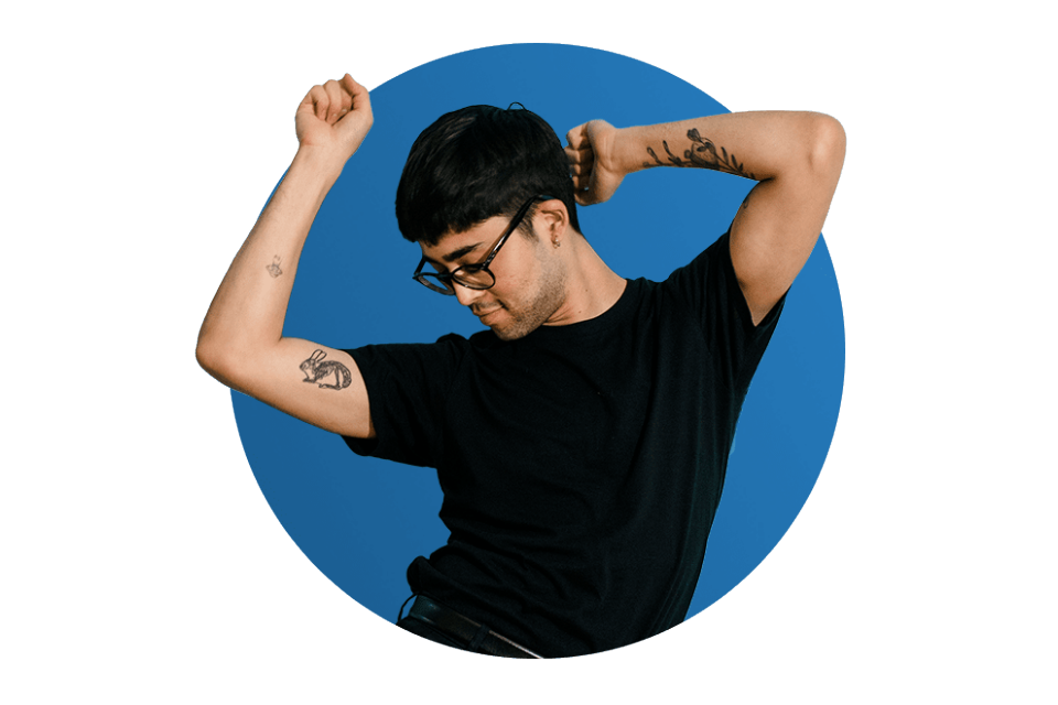 Man with tattoos and glasses dancing
